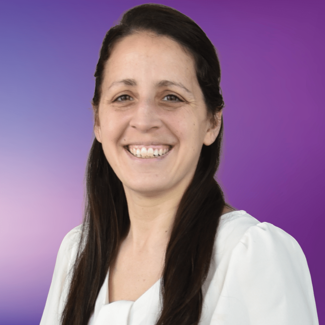 Photo of team member Nicole, smiling, on a purple background